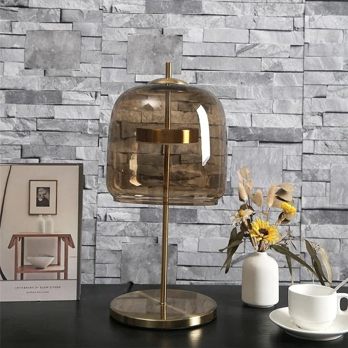 The Smokey Dome table lamp with smoked amber glass on a side table