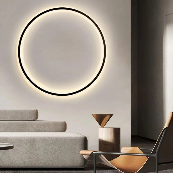 Luminous Halo V1 circular LED ring wall light in warm white glowing above a modern minimalist living room – luxury designer wall light by Luxe Bespoke