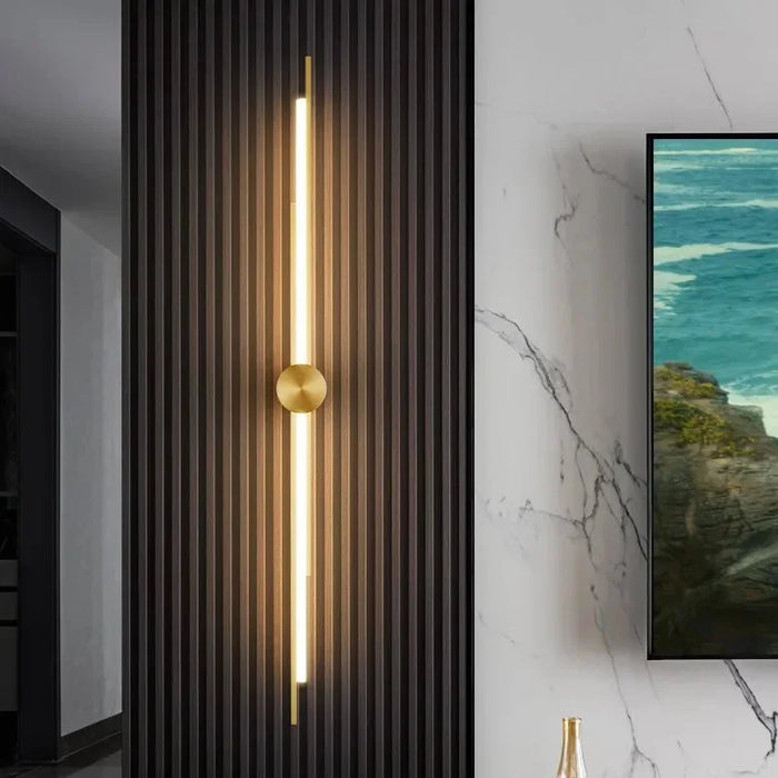 The Vellum Wall Light gold linear LED wall light on a panelled wall