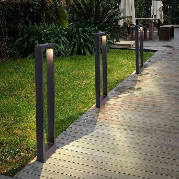 The Lumi Pathway Light black LED bollard lights lining a garden path