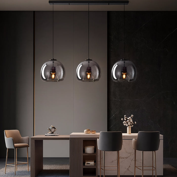 The Velo Pendant Light three smoked glass globes over a dining table