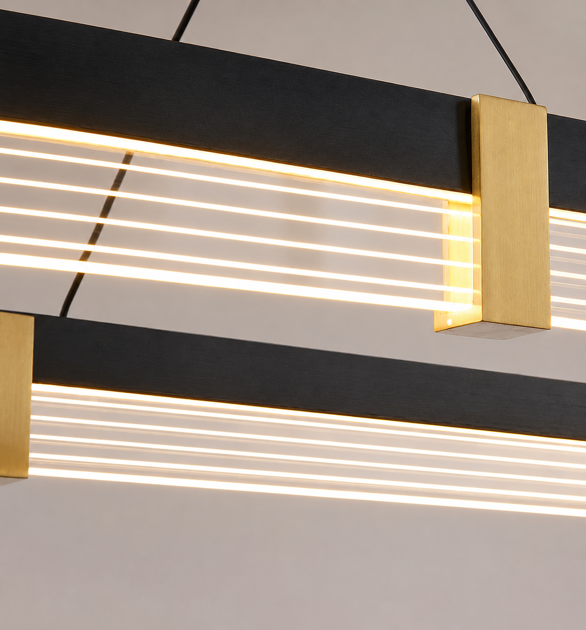 Modern linear LED pendant light fixture with a matte black horizontal bar, gold-toned rectangular end caps, and multiple horizontal white light bars, shown hanging against a light neutral wall.