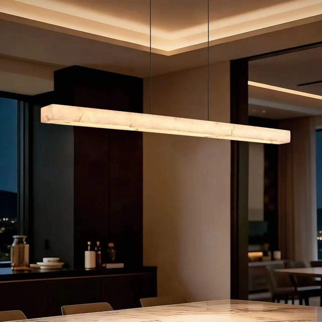 Alabastro onyx-effect linear pendant light hanging over a kitchen island at night