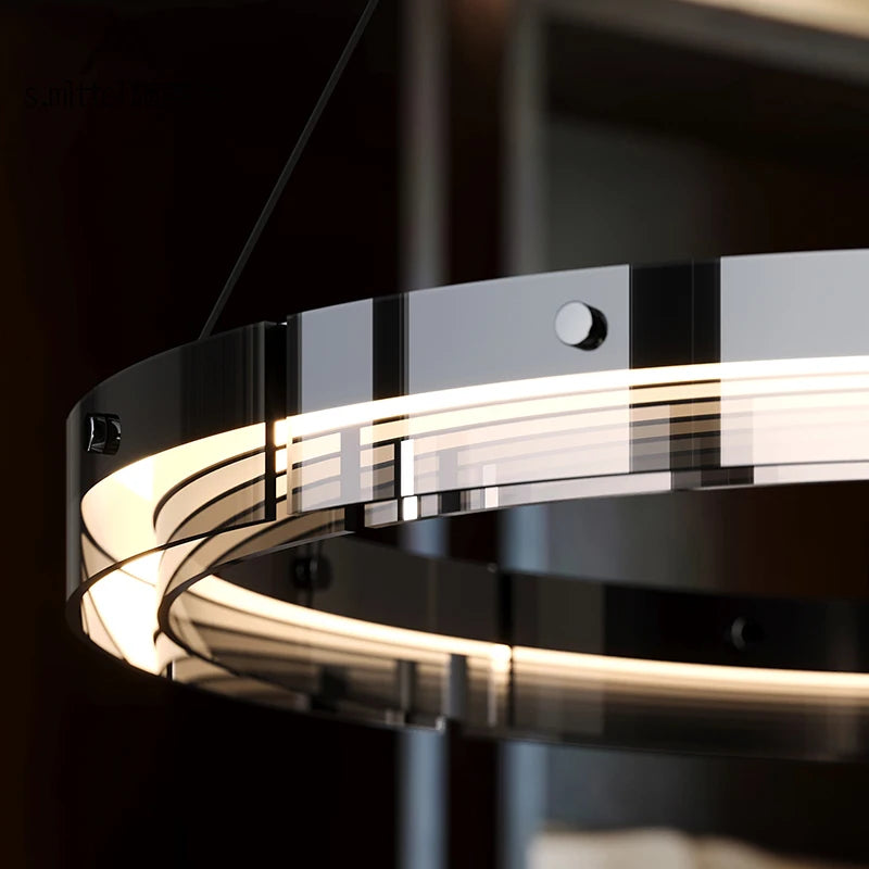 Close-up of the Anello ring pendant light showing the smoked chrome band and glowing acrylic LED diffuser