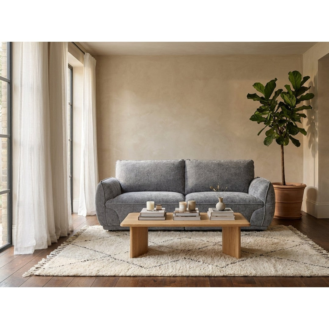 Bergamo 3 seater sofa in grey soft-touch fabric, styled in a bright living room with an oak coffee table