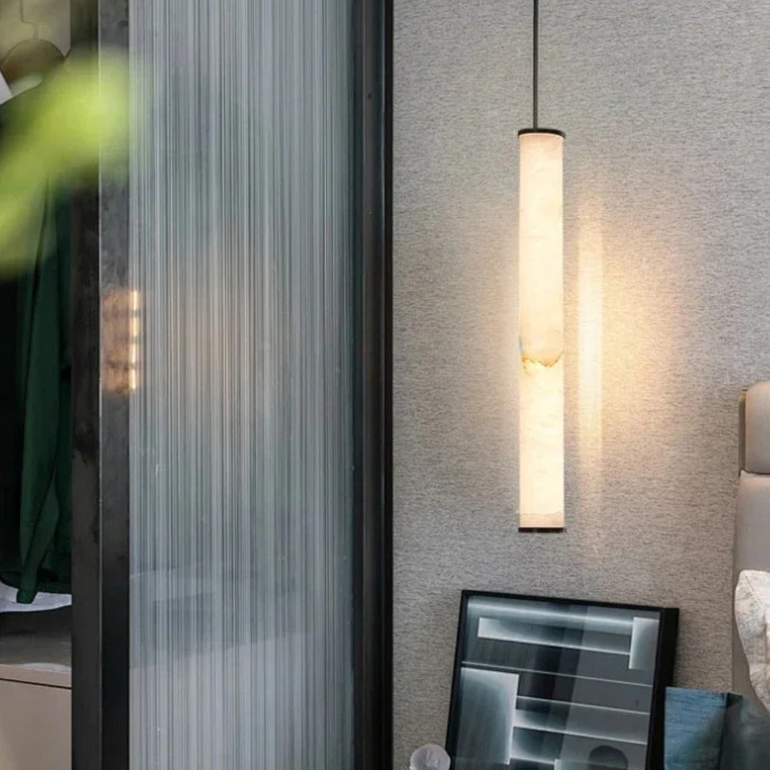 Calacatta marble pendant light hanging beside a reeded glass screen in a stylish bedroom