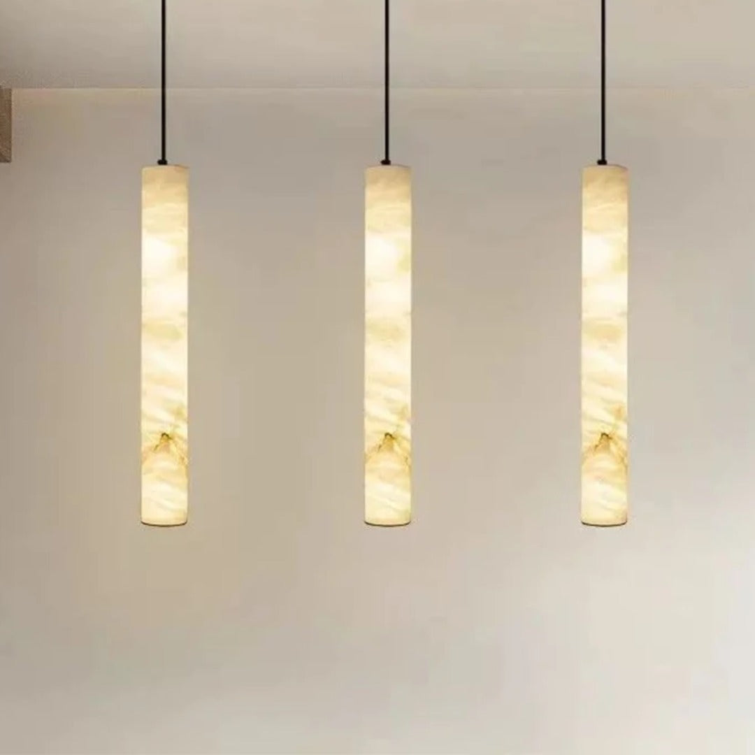 Three Calacatta marble pendant lights hanging in a row for a dining table or kitchen island