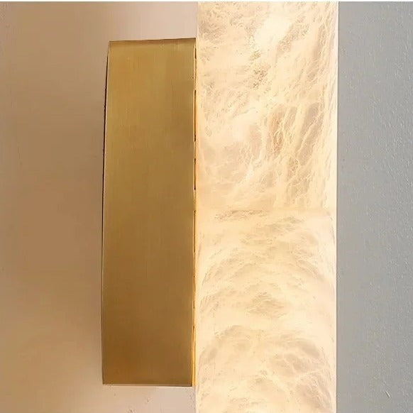 Close-up of the brushed gold wall plate on the Calacatta marble wall light
