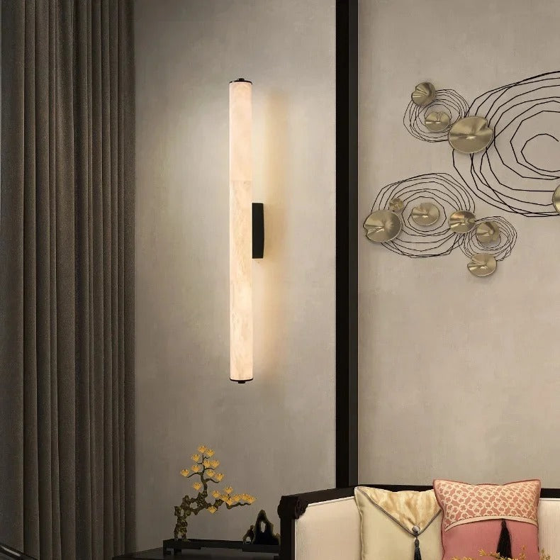 Calacatta marble cylinder wall light illuminating a hallway wall