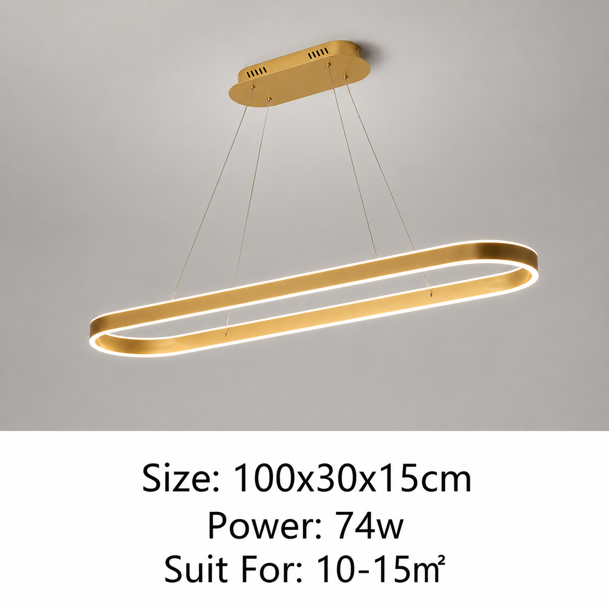 A modern linear LED pendant light in a brushed gold finish, suspended from a matching gold ceiling mount against a light gray wall. Text at the bottom specifies the size (100x30x15cm), power (74w), and suitability for a 10-15m² room.