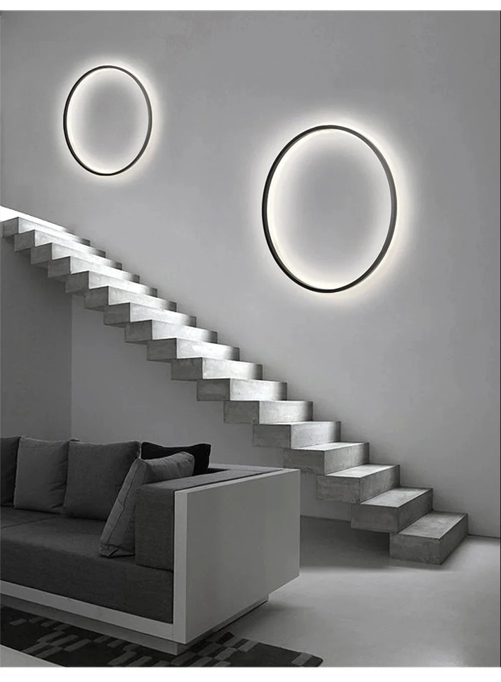 Two Luminous Halo V1 circular LED ring wall lights in different sizes installed on a staircase wall – luxury LED wall lights UK by Luxe Bespoke
