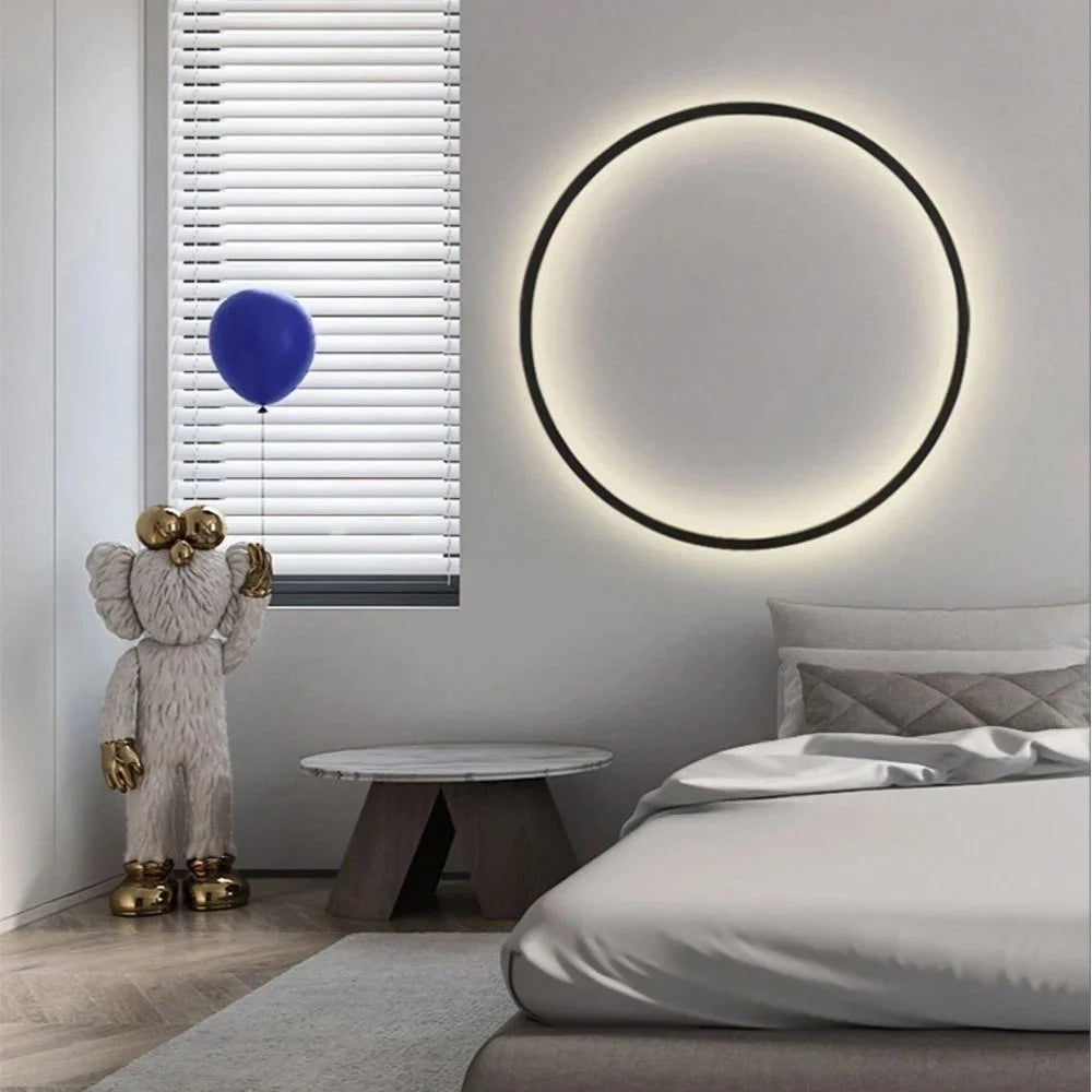 Luminous Halo V1 circular LED halo wall light mounted above a bed in a contemporary bedroom – designer circular wall light UK by Luxe Bespoke