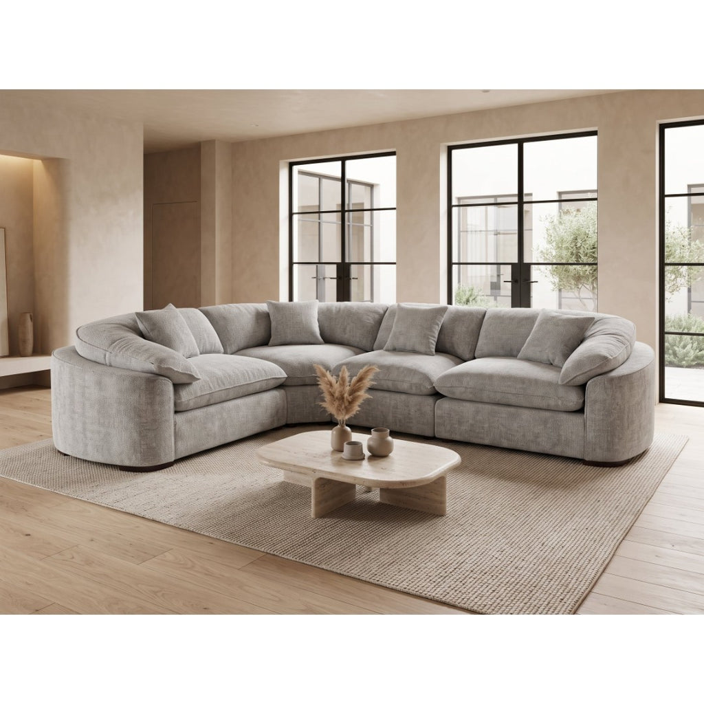Helena curved corner sofa in soft grey fabric with rounded arms, shown from the opposite angle