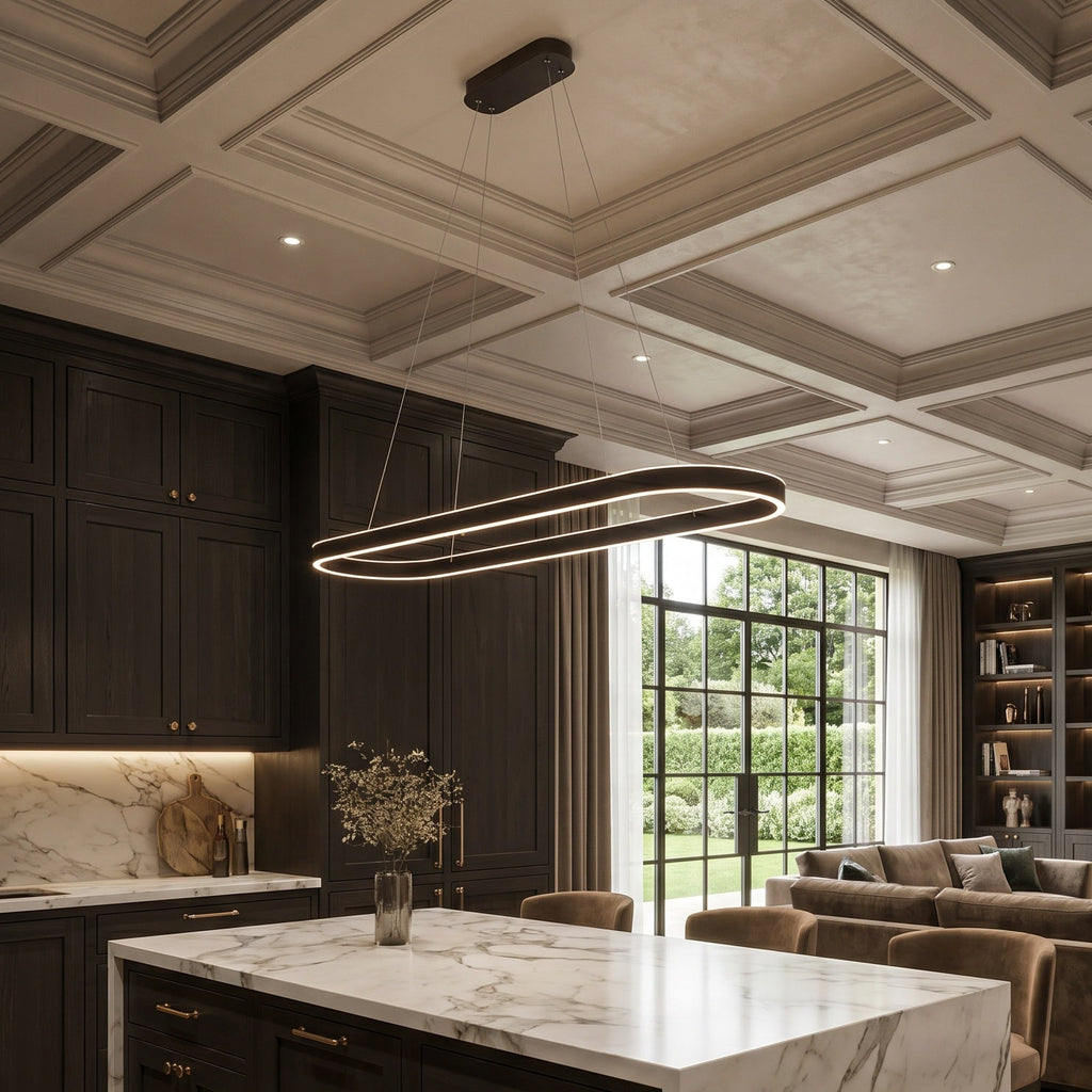 A luxury modern kitchen island with a white marble countertop and dark wood cabinetry, set in a spacious, elegant living room with a fireplace, bookshelves, and a large window.