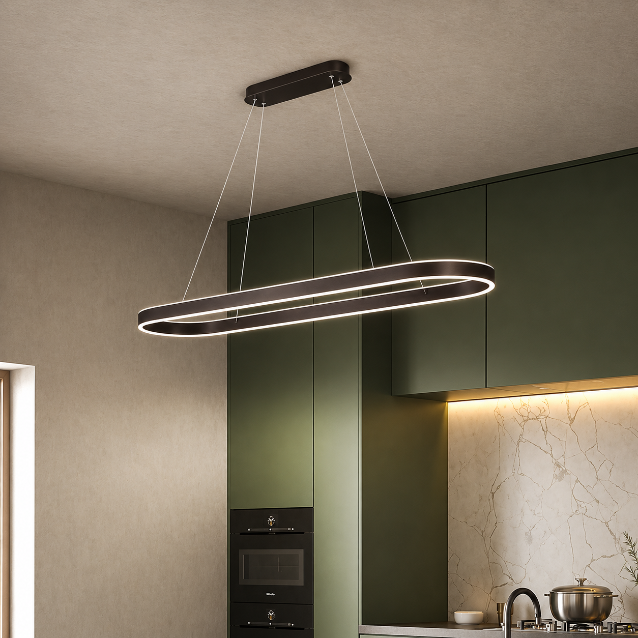 A modern linear LED pendant light with a black frame and dual concentric rings, suspended from the ceiling in a contemporary kitchen with dark green cabinets.