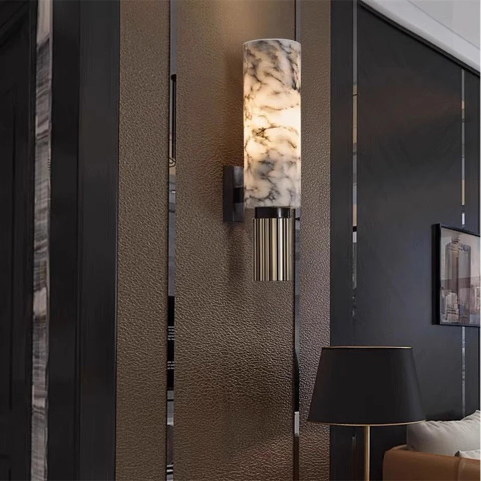 Marmora marble wall light lit against a dark panelled wall