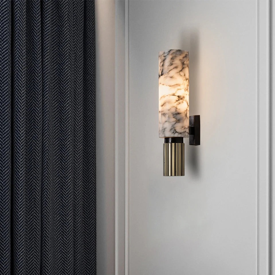 Marmora marble wall sconce on a panelled wall beside dark curtains