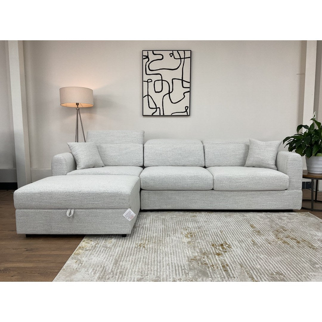 Front view of the beige Milano corner sofa with adjustable headrests and scatter cushions