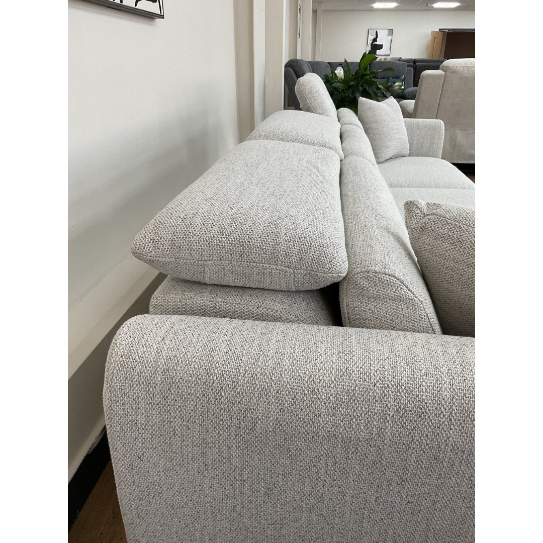 Side view of the beige Milano sofa with headrests raised