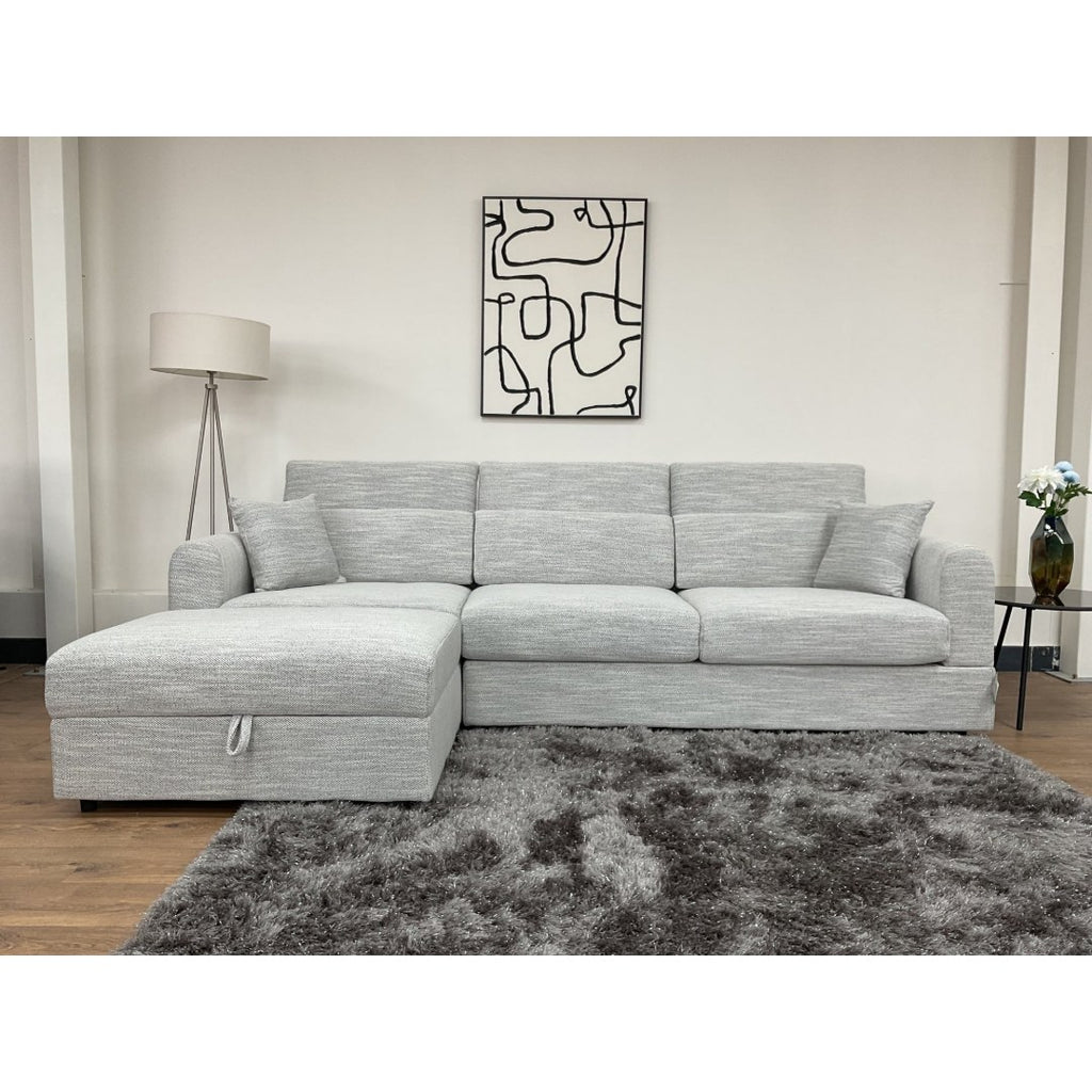 Front view of the grey Milano corner sofa showing the chaise, deep seats and scatter cushions
