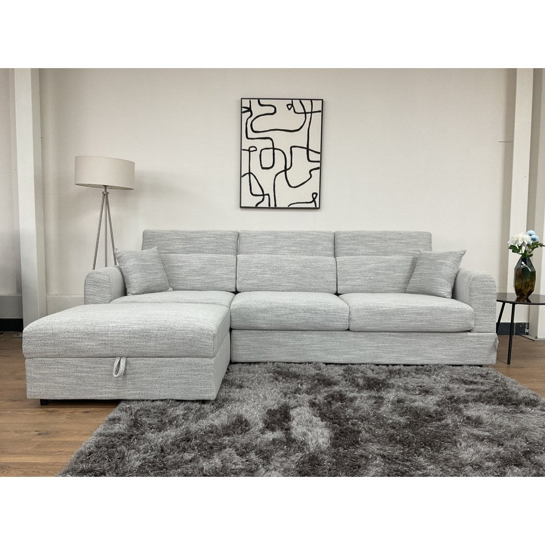 Front view of the grey Milano corner sofa showing the chaise, deep seats and scatter cushions